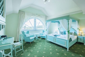 A bedroom with a four-poster bed, two chairs, a small table, and a window with curtains. - Ferien Hotel Fläming (Rabenstein/Fläming)