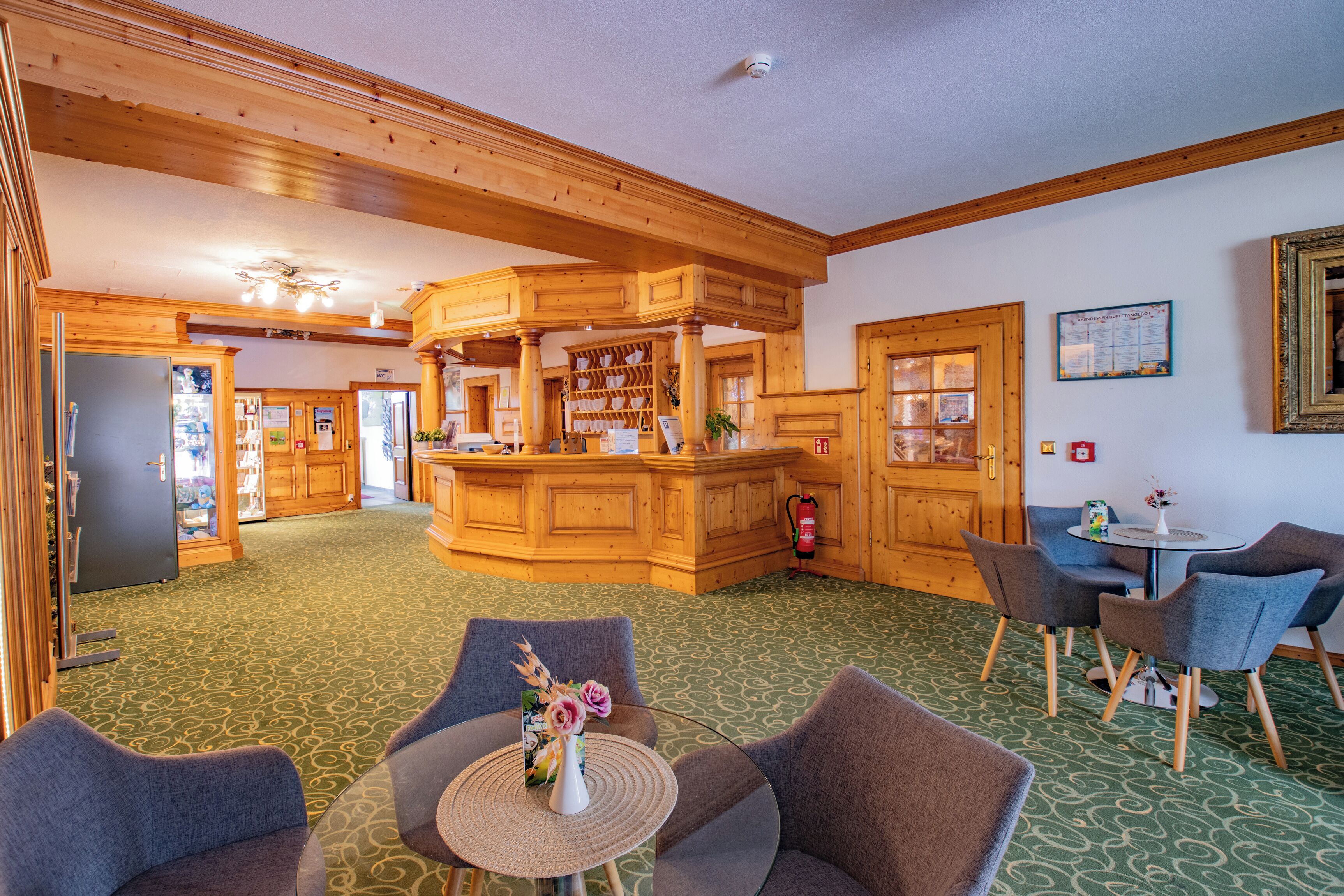 A spacious lobby with wooden architecture, a central bar area, and seating arrangements.
