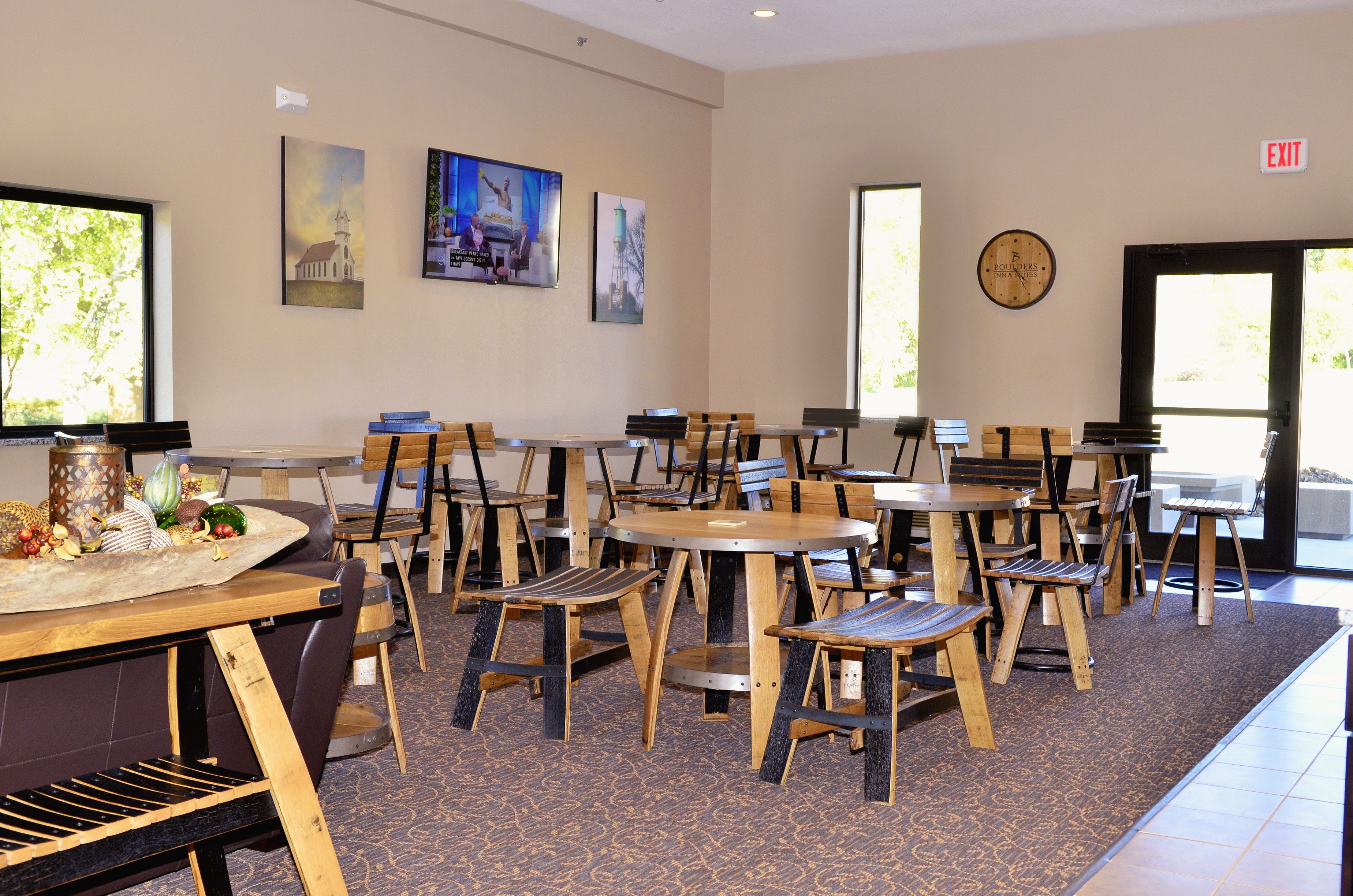 A dining area with multiple tables and chairs, a clock on the wall, and artwork on the walls.