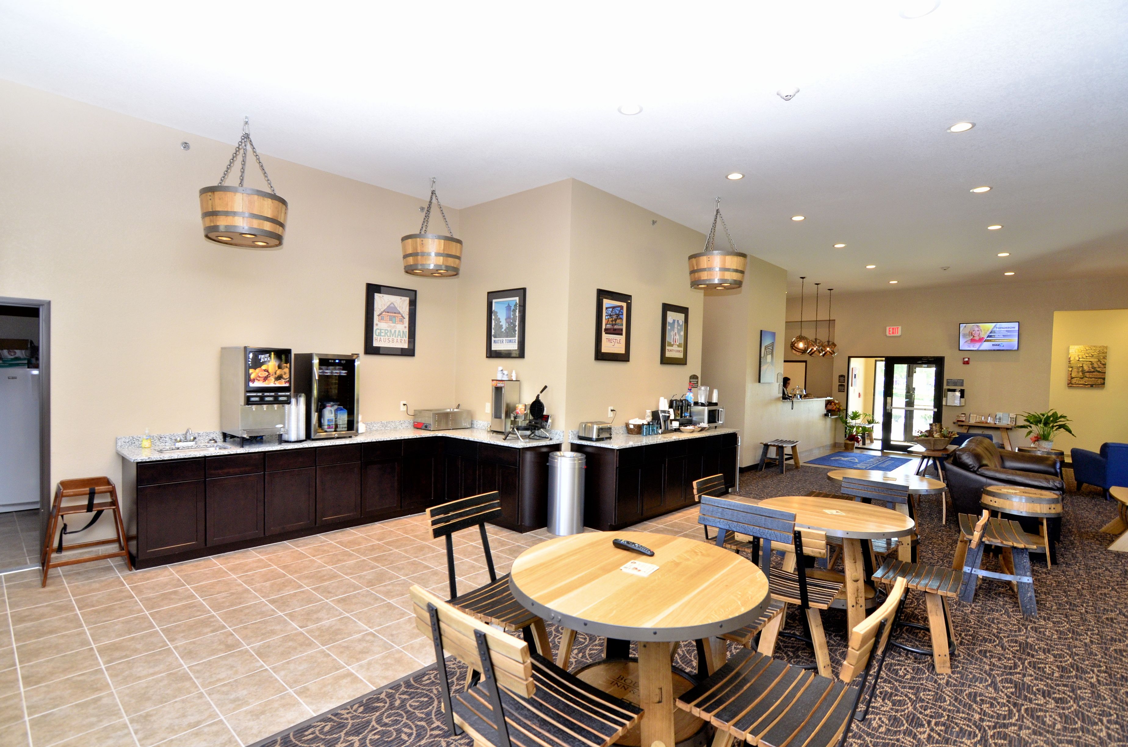 A hotel lobby with a bar area, seating, and a television screen.