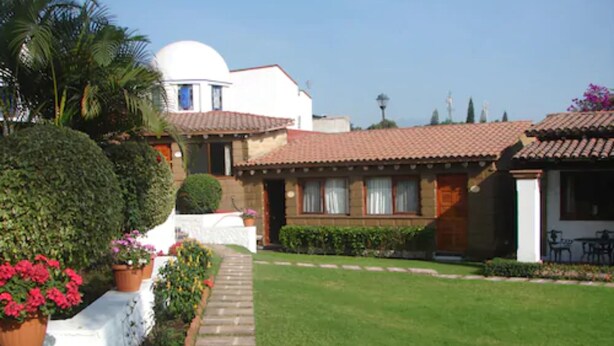 Una villa de estilo mediterráneo tradicional con un patio central, paredes blancas y tejas de terracota.