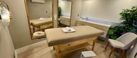 A modern bathroom with a wooden bench, a small stool, a mirror, and a sink.