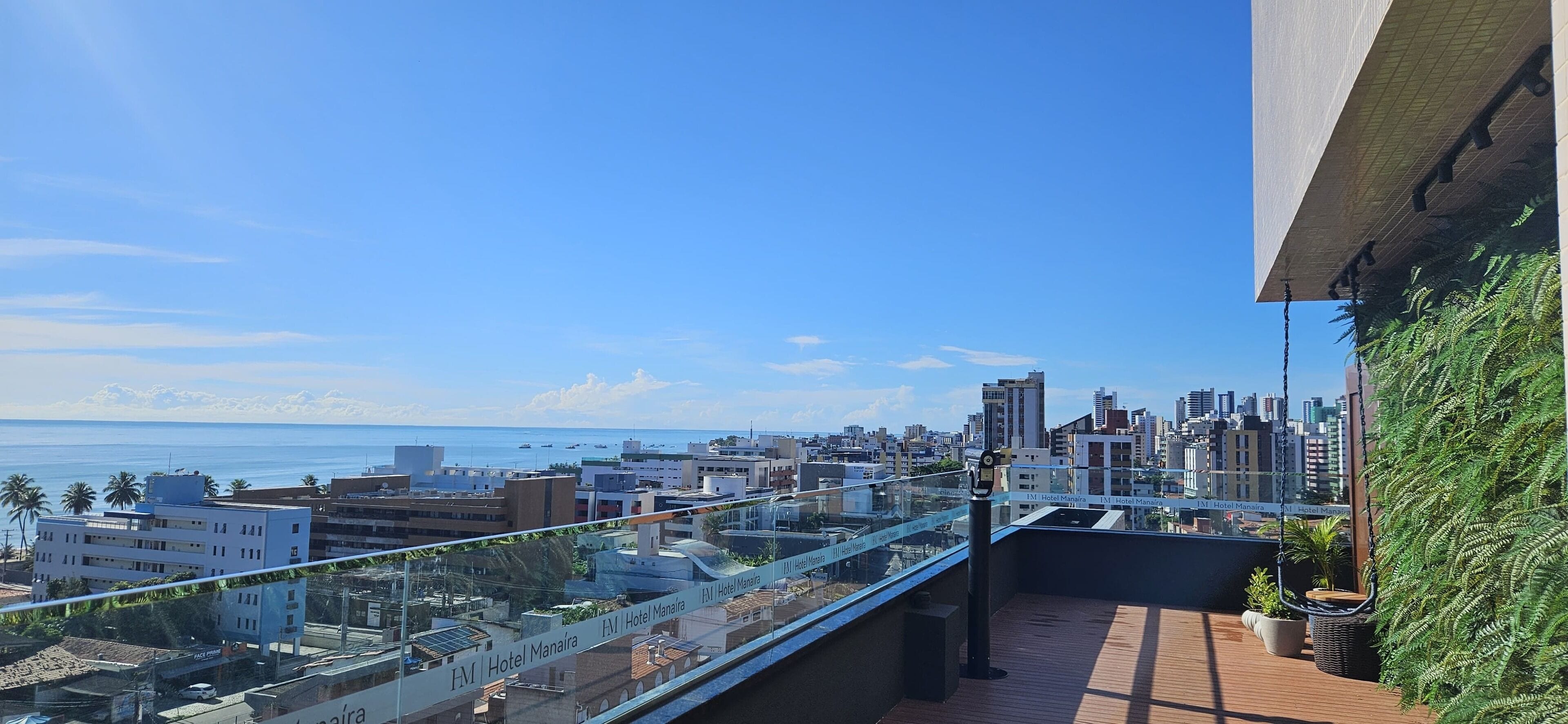 Una terraza en la azotea con vistas al horizonte de la ciudad y al océano.
