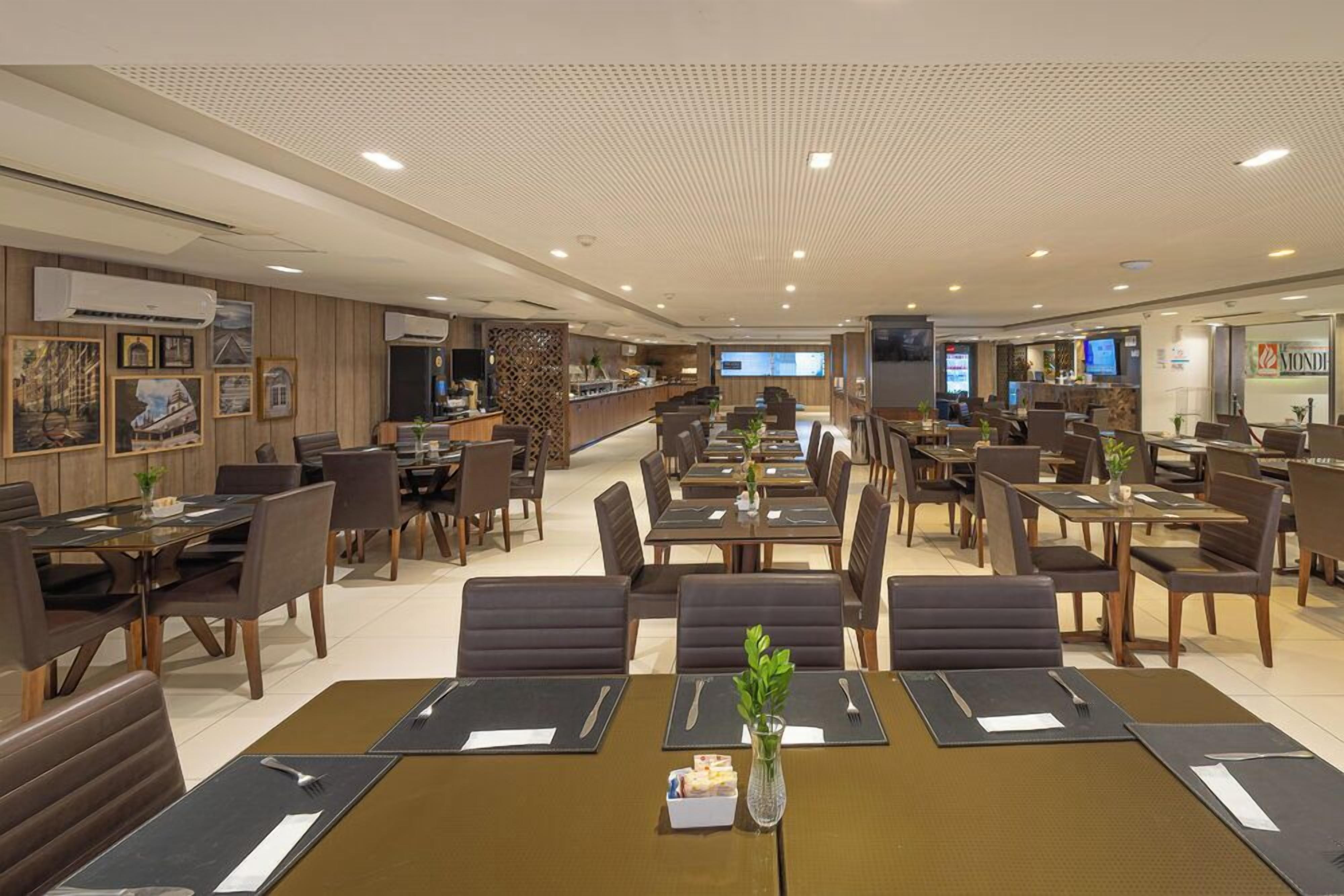 Un restaurante espacioso con varias zonas de comedor, incluyendo cabinas y mesas, y una barra para ordenar.