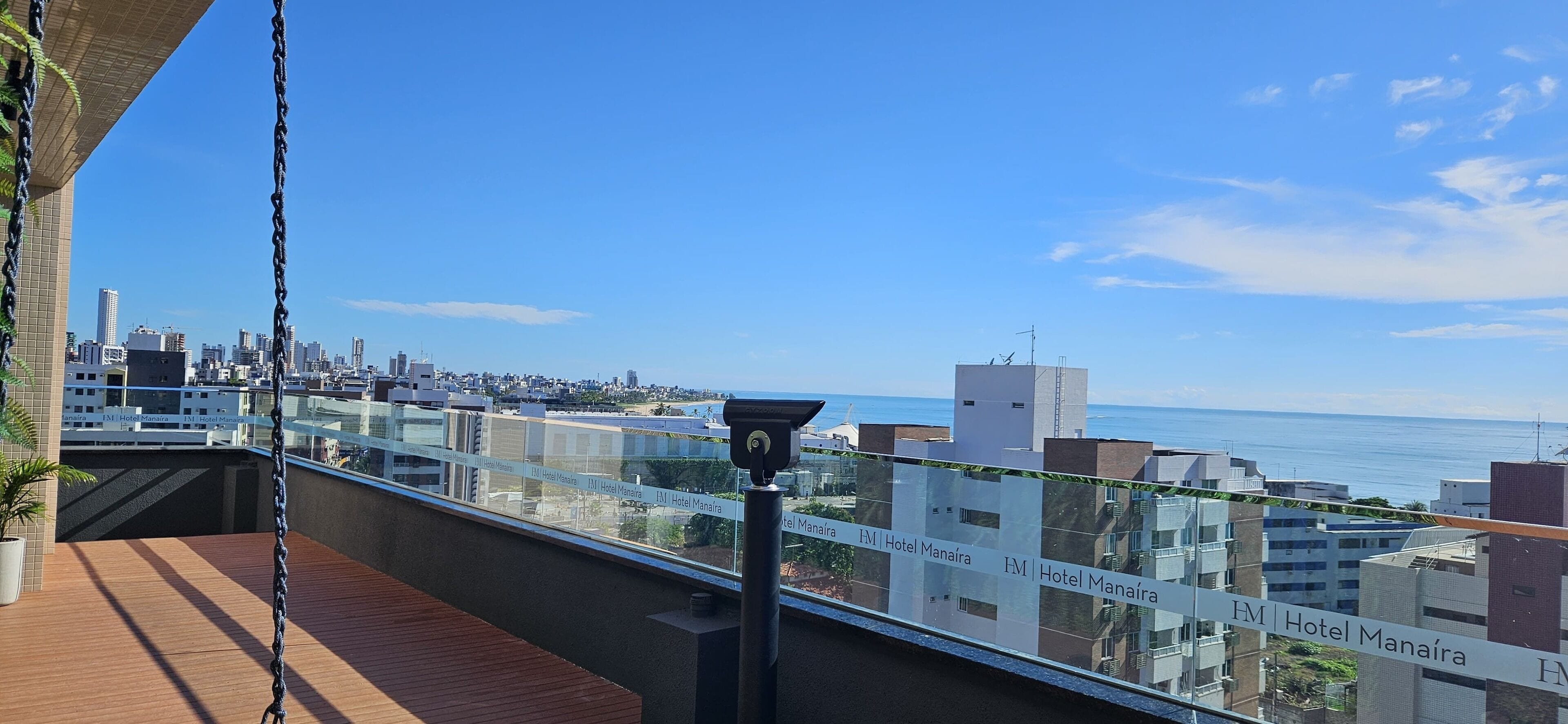 Un balcone con vista libera sullo skyline cittadino e sul mare.