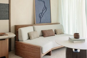A modern room with a sofa, a table, and a wall art piece. - Alila Mayakoba (Playa del Carmen)