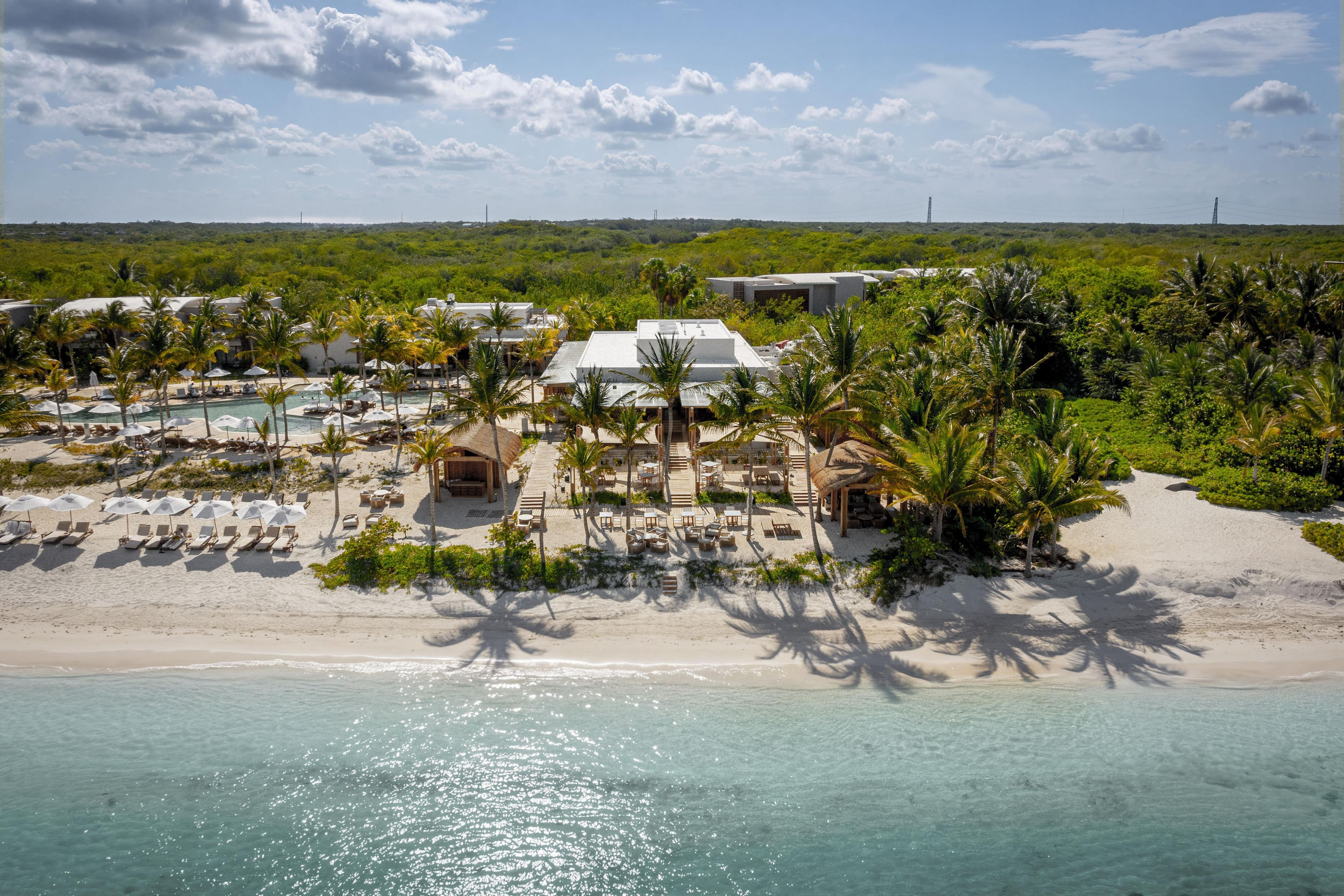 Ein Resort mit Pool, Strand und Palmen.