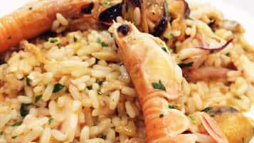 A plate of seafood paella with shrimp and mussels.