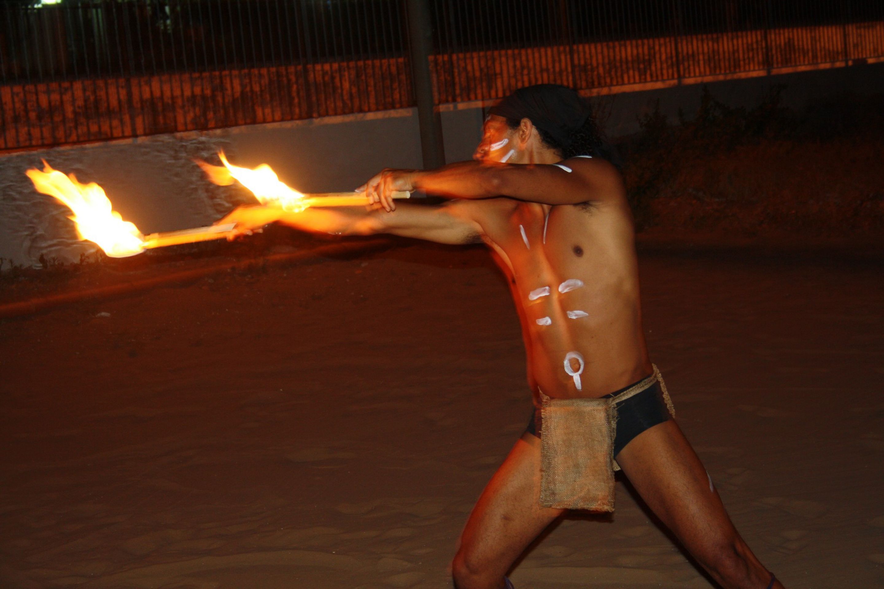 A person performing a fire act outdoors at night.