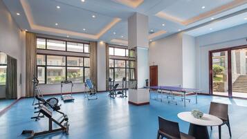 Stay active with our fitness center, featuring exercise machines and a ping pong table.