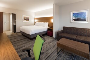 Una habitación de hotel con una cama, un sofá, un escritorio y una silla.