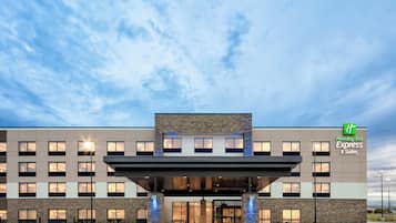 Edificio de Holiday Inn Express & Suites con un diseño arquitectónico moderno, que presenta un techo plano, ventanas amplias y una entrada destacada.