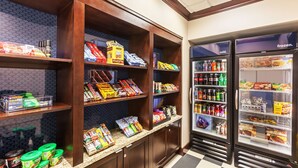 Una despensa de hotel con estantes repletos de aperitivos, bebidas y productos envasados.
