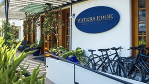 A hotel entrance with a sign reading "WATERS EDGE hotel • tiburon" and bicycles parked outside. - Waters Edge Hotel (Tiburon)
