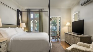 A hotel room with a four-poster bed, a television, a cabinet, and a chair. - Mill Valley Inn (Mill Valley)