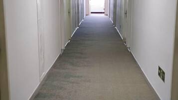 A long, narrow hallway with doors on both sides, leading to individual rooms.