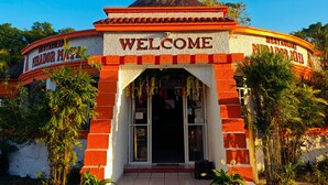 Un edificio con un letrero de 'Welcome', techo de paja y fachada de ladrillo.