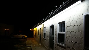 A building with a textured exterior and a single visible door. - Hat Motel (Medicine Hat)