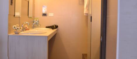 Ein Badezimmer mit Waschbecken, Spiegel und Dusche.