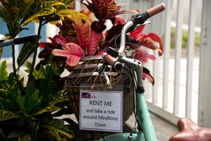 Uma bicicleta com uma placa que diz 'ALUGUE-ME e dê uma volta por Miraflores'.