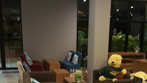 Un área de descanso moderna con sofás, una mesa de centro y un oso de peluche.