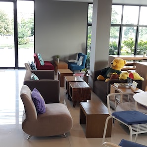 Ein modernes Wohnzimmer mit Sofas, einem Couchtisch und einem großen Teddybären.