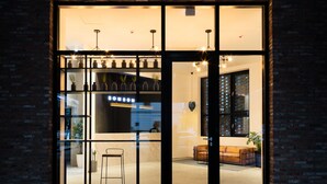 A modern interior with a glass door entrance, a seating area with a sofa and chairs, and a visible sign that reads "BOMBOM". - Gangneung Boutique Hotel Bombom (Gangneung)