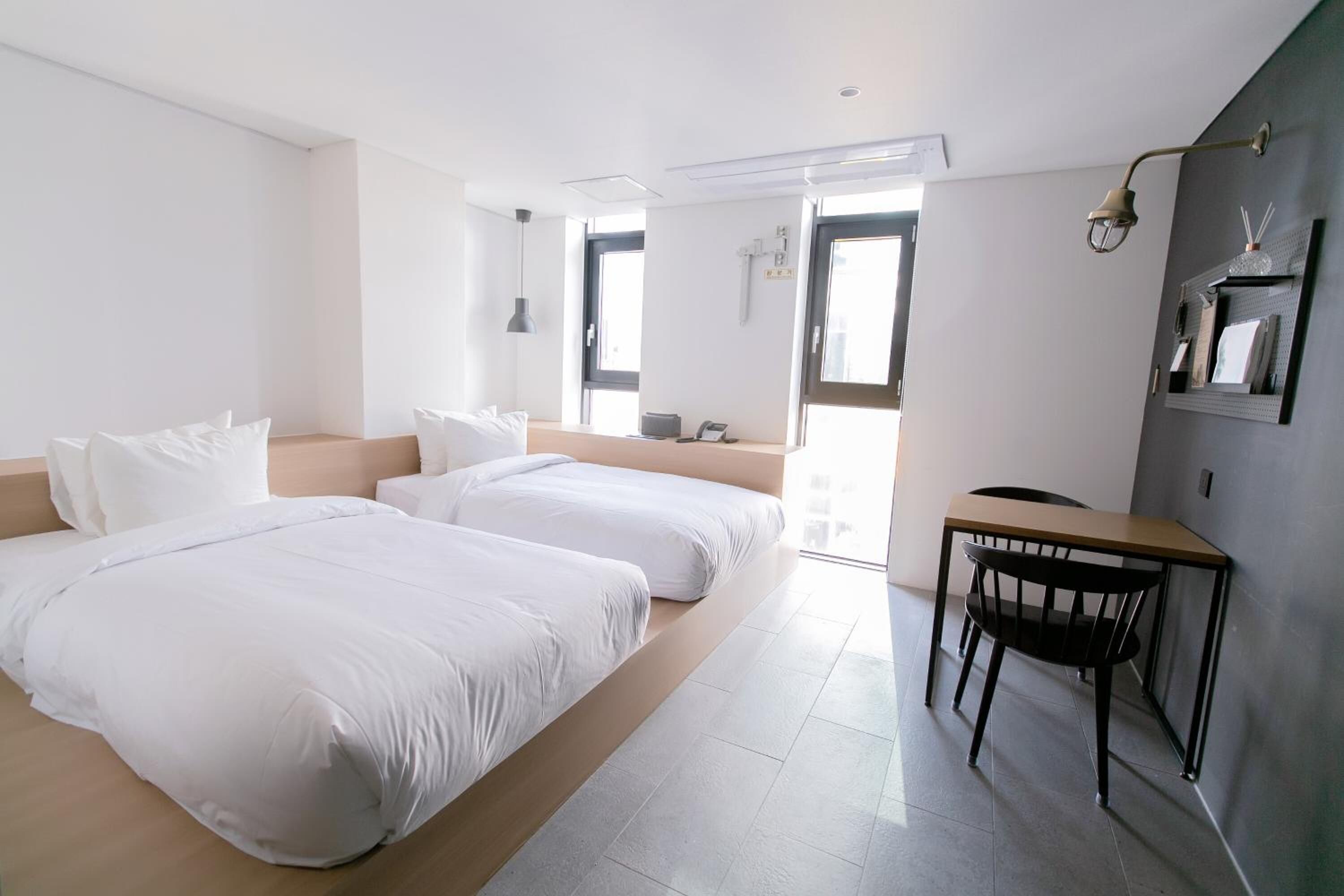 Una habitación de hotel moderna con dos camas, un escritorio y una silla.