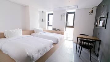 Una habitación de hotel moderna con dos camas, un escritorio y una silla.