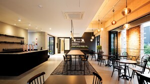 A modern hotel lobby with a long reception desk, seating area, and large windows. - Gangneung Boutique Hotel Bombom (Gangneung)