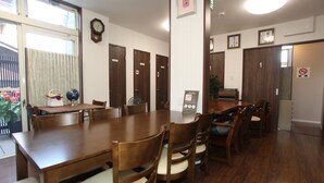 A dining area with wooden tables and chairs, a clock on the wall, and a sign indicating room number 1.