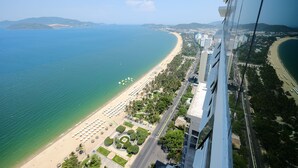 Vista aérea de una ciudad costera con playa, rascacielos y cielo despejado.