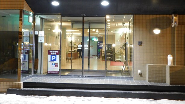 A hotel entrance with glass doors, a sign above indicating the name, and a parking sign to the left. - Hotel Crown Hills Kitami (Kitami)