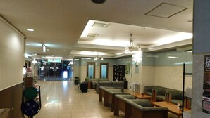 A hotel lobby with seating areas, a reception desk, and a clear view of the entrance. - Hotel Crown Hills Kitami (Kitami)
