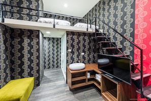 A compact hotel room with a bunk bed, a TV, a wooden vanity, and a small yellow chair. - Ch Place X Hotel (Taipei)