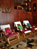 Una habitación con muebles de madera, incluyendo un sofá y sillones, una mesita y una escalera.