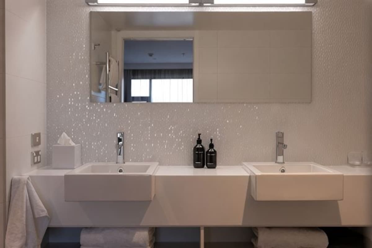 A bathroom with two sinks, a mirror, and a window.