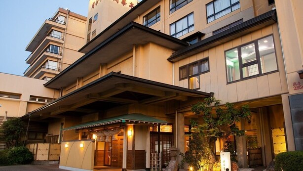 A multi-story hotel with a traditional entrance, a covered outdoor area, and a visible sign indicating the name and address. - Kaikatei (Hamamatsu)