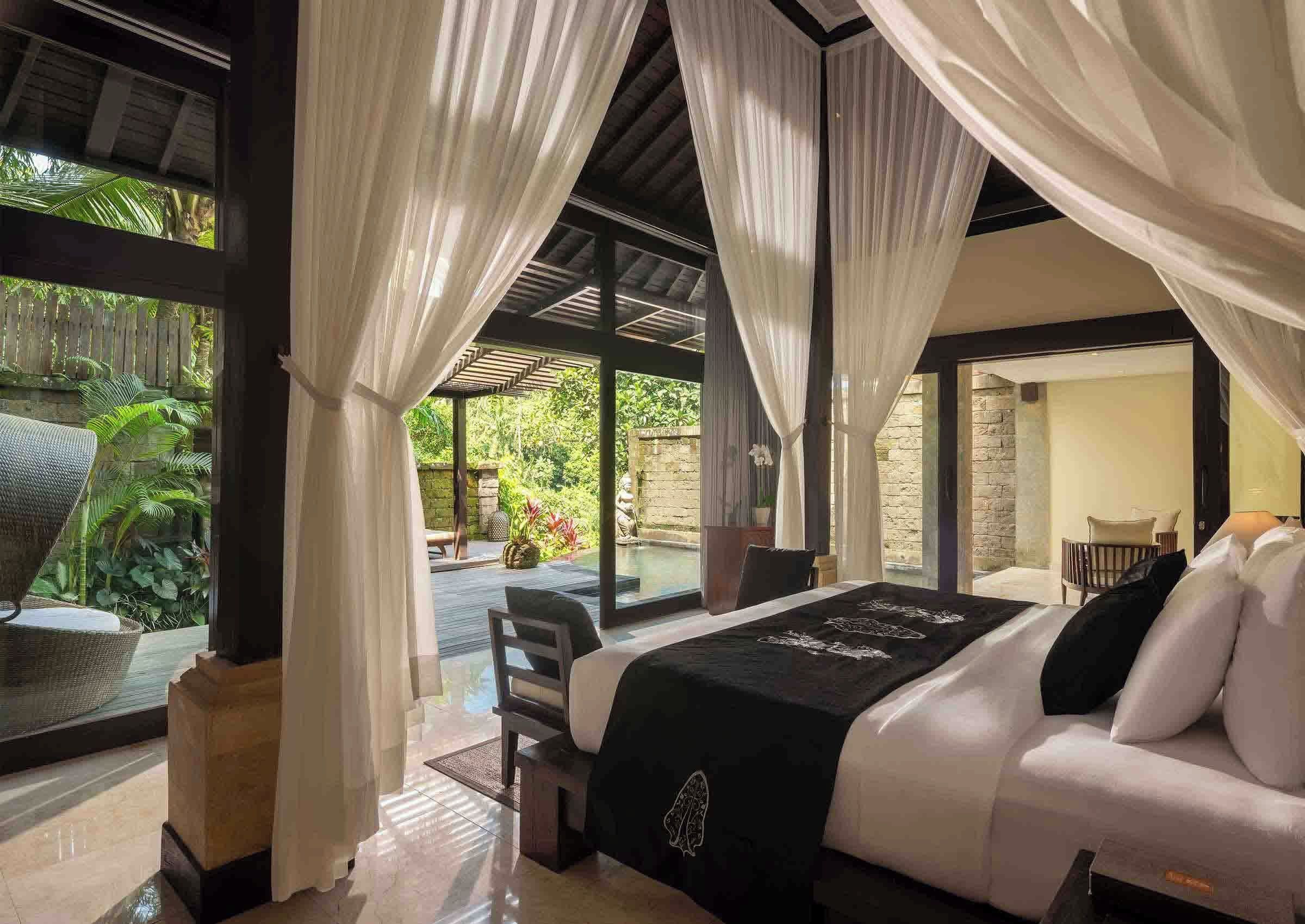 Un dormitorio con cama, vistas a un jardín y un balcón.