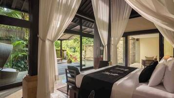 Un dormitorio con cama, vistas a un jardín y un balcón.