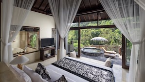 Un dormitorio con una cama grande, televisor y vistas a un jacuzzi y zona exterior.