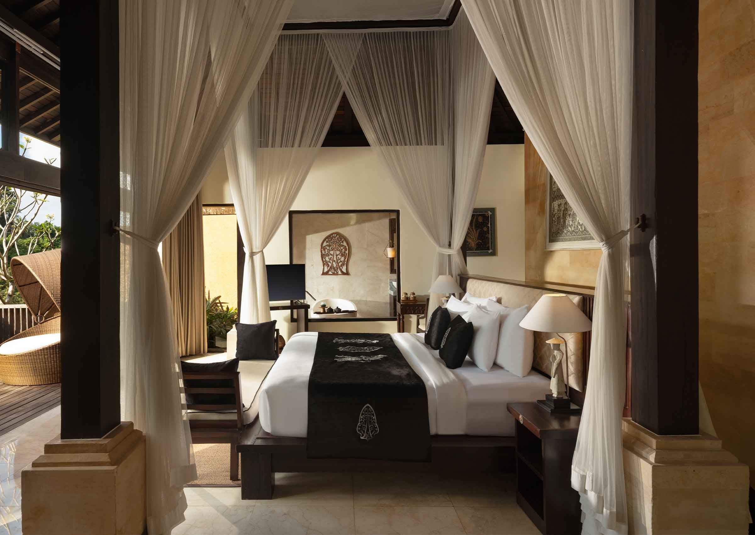 A bedroom with a bed, bedside tables, a nightstand, a lamp, and a decorative wall piece.