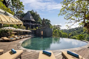 A pool with lounge chairs and a stone statue. - The Kayon Valley Resort Ubud (Ubud)
