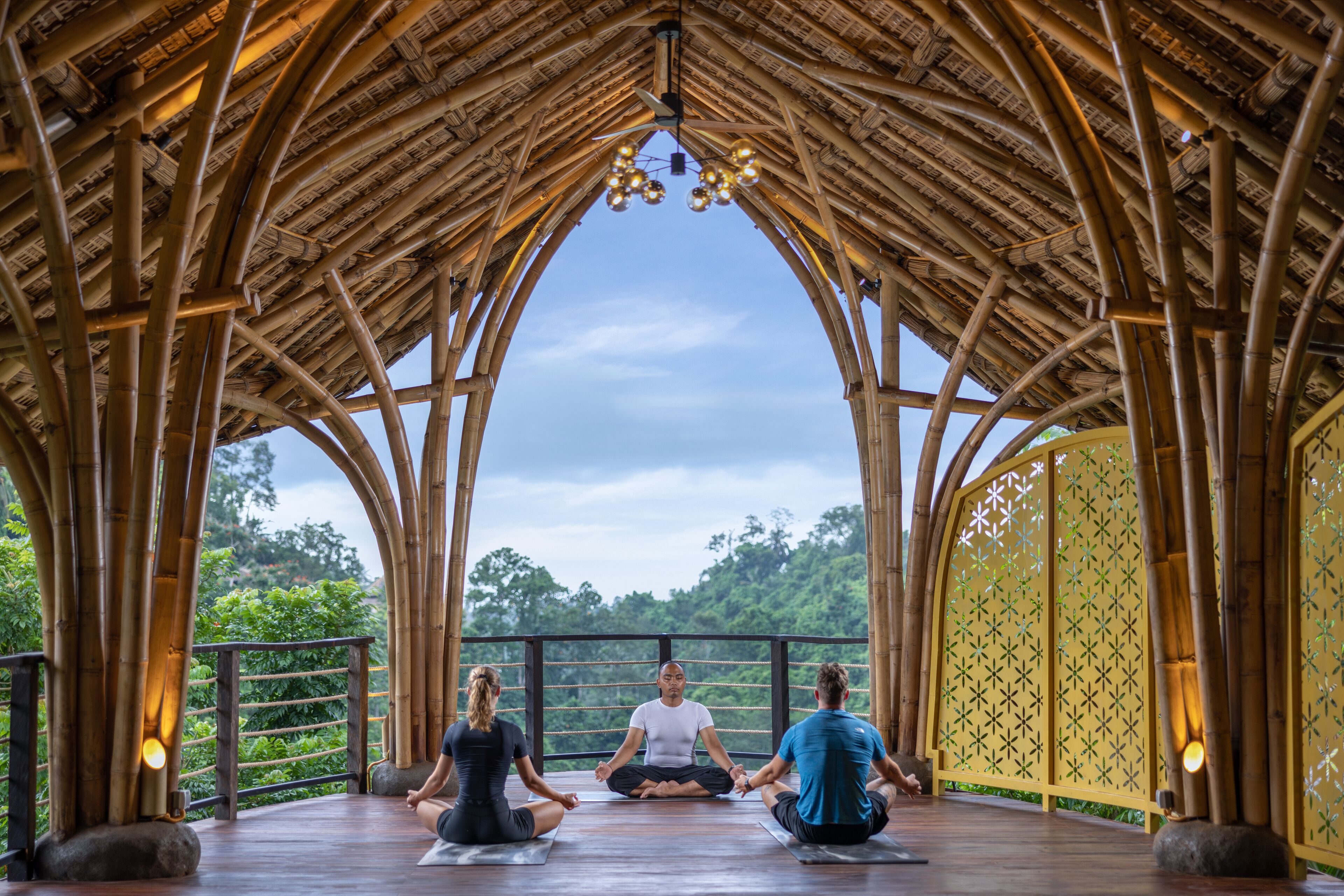 Ett område avsett för meditation med en struktur av bambu, utsikt över grönskan och en lugn atmosfär.