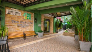 The entrance of Tee Pak Dee, a residential hotel in Phuket, with a tiled walkway, benches, and potted plants. - Tee Pak Dee Resident Phuket (Phuket)