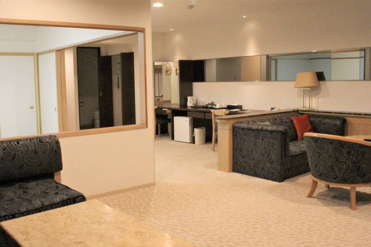 Uma sala de estar moderna com sofá, mesa de centro e área de jantar com mesa e cadeiras.