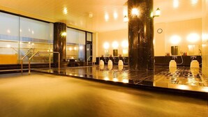 A modern hotel lobby with a large reception desk, a glass wall offering a view of the outside, and a spacious area with a water feature. - Hotel Cypress Karuizawa (Karuizawa)