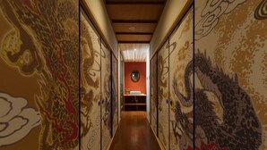 A hallway with traditional Asian-style wall paintings and a wooden floor.