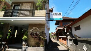 A building with a sign for 'KONDRA PREMIER' and a sign for 'INTERNET SHIMANO POOL TOUR SERVICE'.