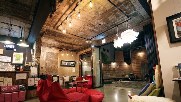 Un interior acogedor con una zona de bar, asientos y una decoración original con un ovillo de lana.